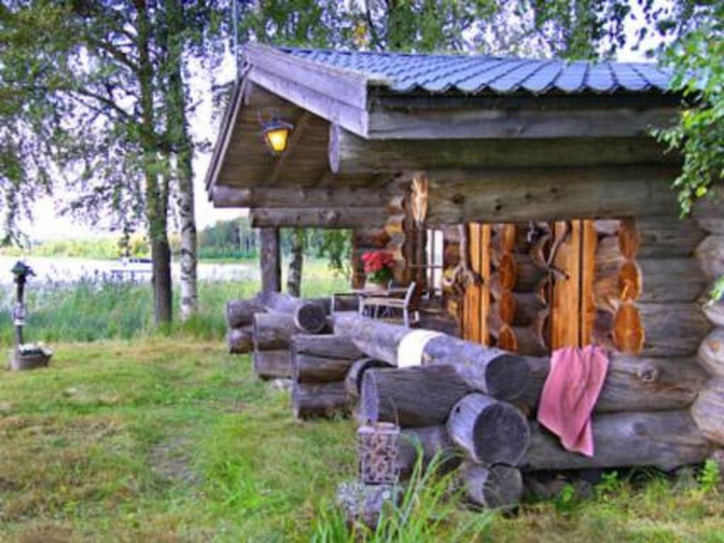 uma cabana de madeira num campo relvado com uma mesa em Holiday Home Kopinkallio 3 by Interhome em Pätiälä