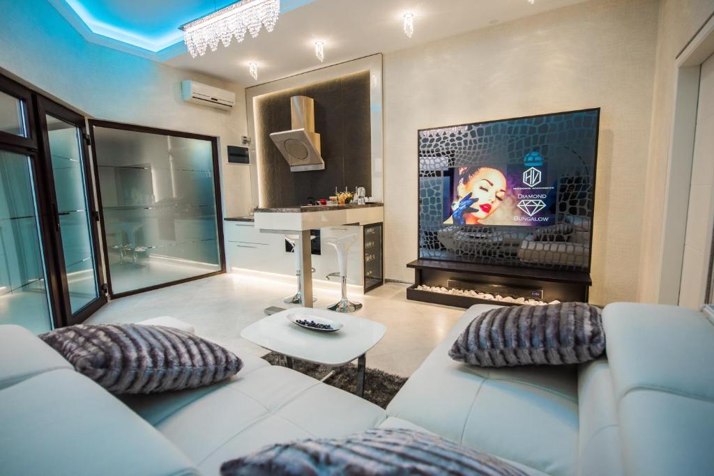 ein Wohnzimmer mit einer weißen Couch und einem Kamin in der Unterkunft H & V Residence - Diamond Bungalow Apartment in Arad