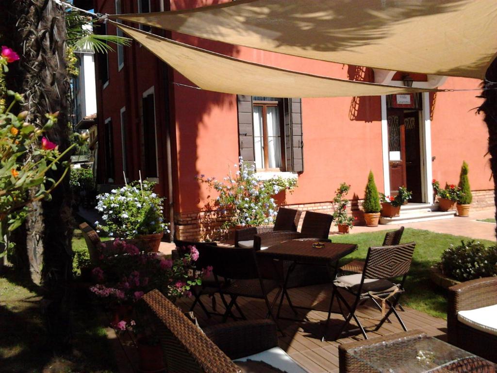 a patio with a table and chairs and flowers at Villa Casanova in Venice-Lido