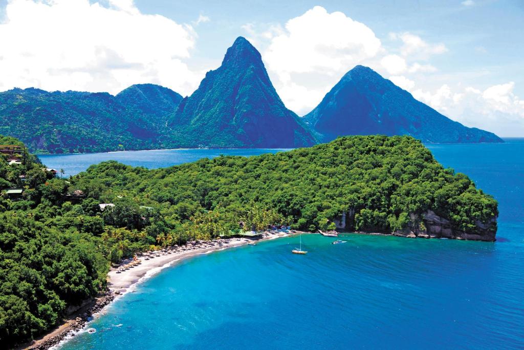 uma ilha no oceano com montanhas ao fundo em Anse Chastanet Resort em Soufrière