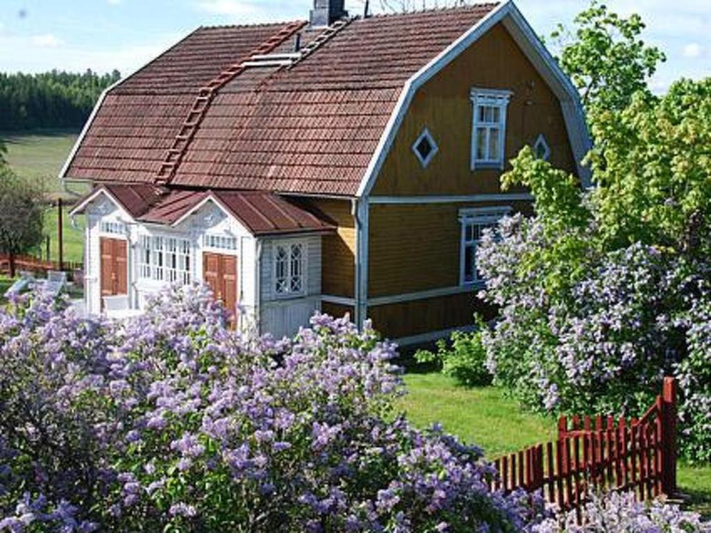 een klein huis met een rood dak en wat bloemen bij Holiday Home Louhela by Interhome in Kisko
