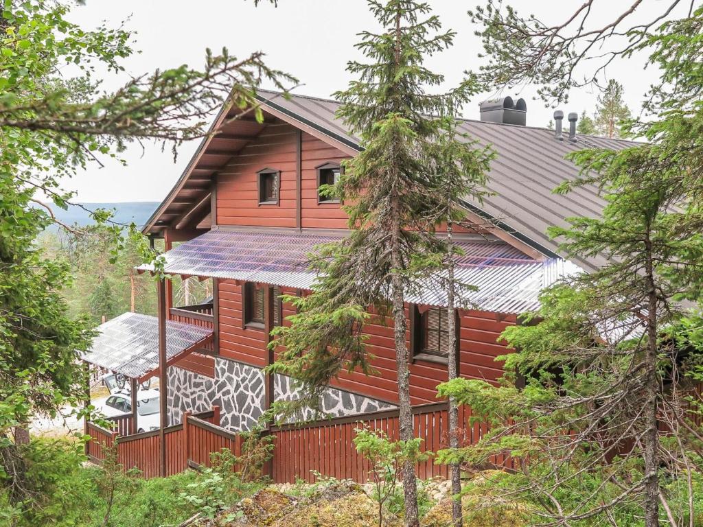 uma casa de madeira com uma cerca na floresta em Holiday Home Kärpänrinne b by Interhome em Syöte