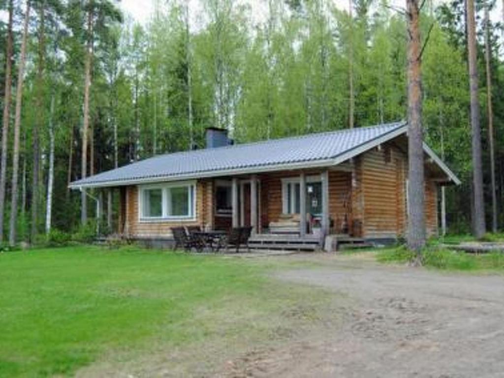 a log cabin in the middle of a forest at Holiday Home Köökuu by Interhome in Heinäkylä