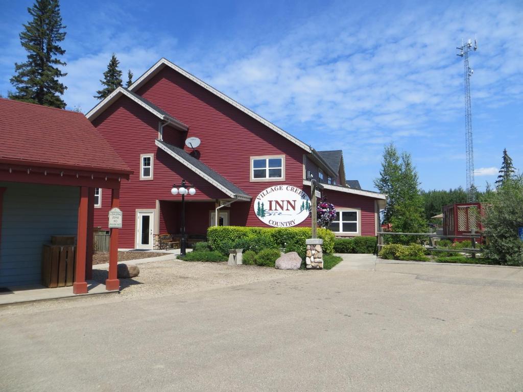 a red building with a sign on the front of it at Village Creek Country Inn in Westerose