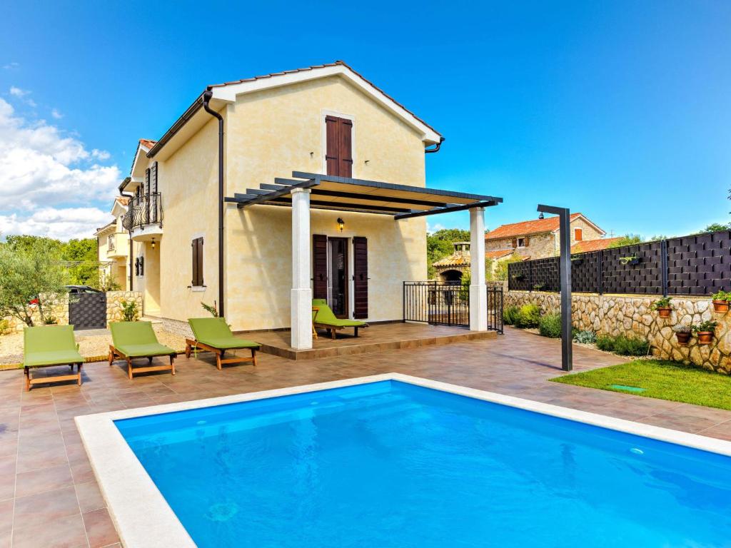 a villa with a swimming pool in front of a house at Holiday Home Villa Willheim in Sveti Ivan Dobrinjski