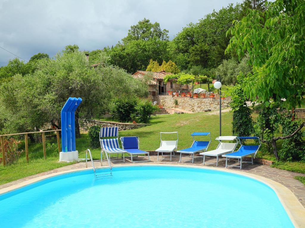 a swimming pool with chairs and a table at Holiday Home Ca' di Bacco-2 by Interhome in Nestore