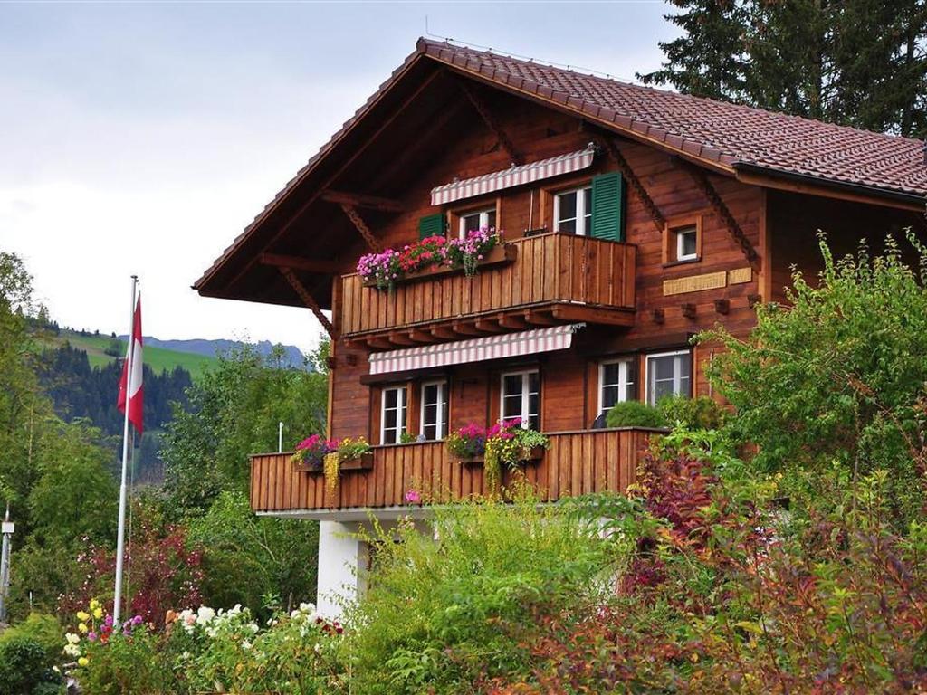 a wooden house with flower boxes on the balcony at Apartment Christeli by Interhome in Zweisimmen