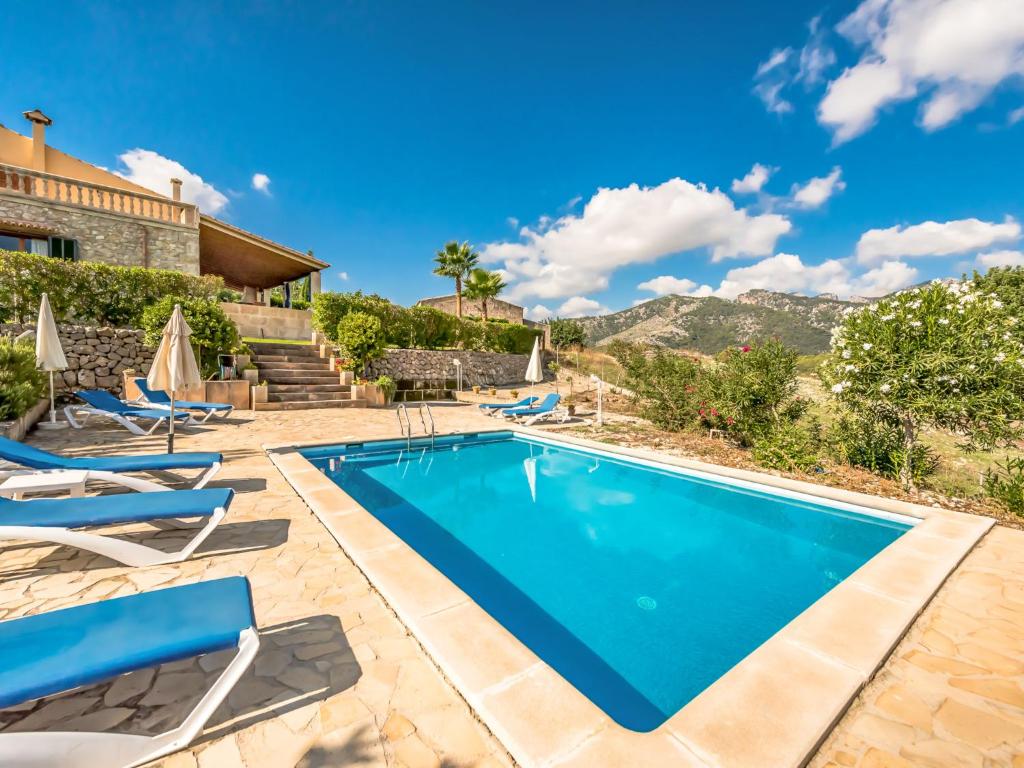 een villa met een zwembad en stoelen bij Holiday Home Sa Coma de Campanet by Interhome in Campanet