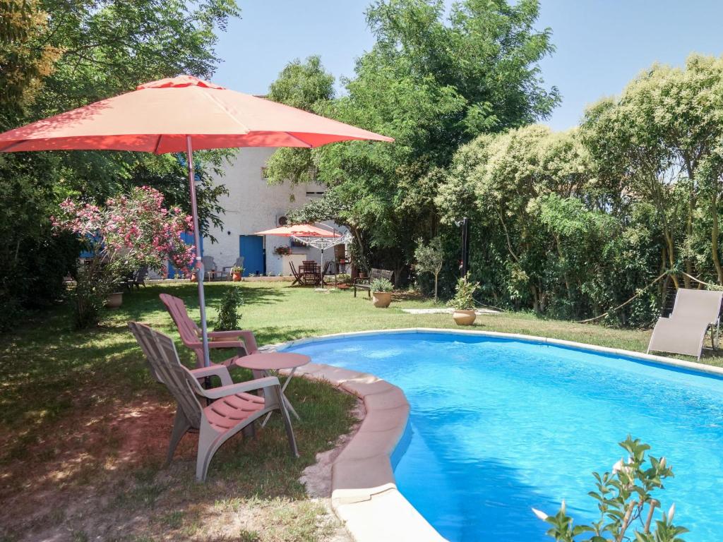 - une piscine avec 2 chaises et une table avec un parasol dans l'établissement Apartment La maison d'Adélaïde by Interhome, à Aigues-Mortes