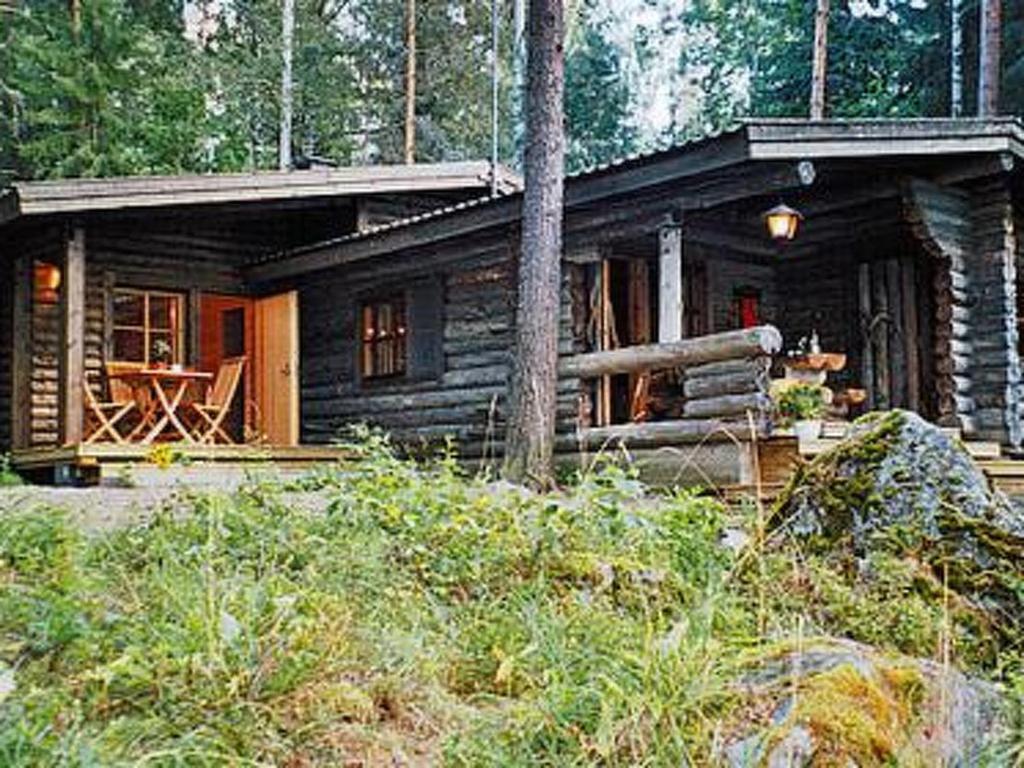 a log cabin in the middle of a forest at Holiday Home Kultaranta by Interhome in Pätiälä