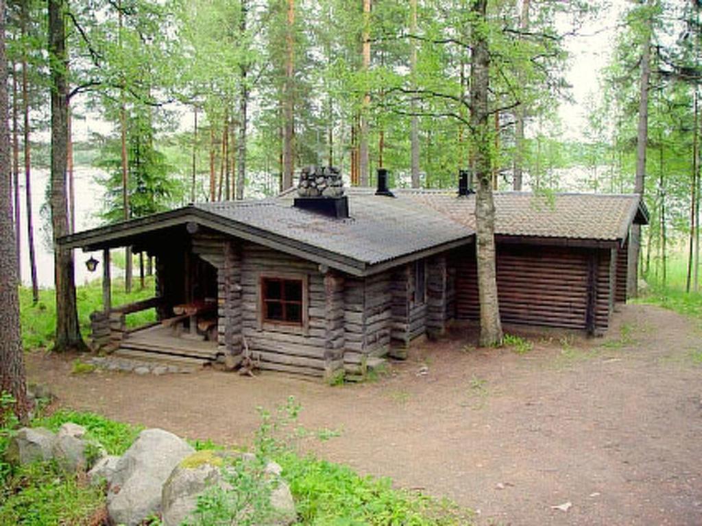 uma cabana de madeira no meio de uma floresta em Holiday Home Divaanikivi by Interhome em Pätiälä