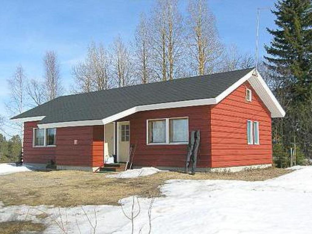 a red house with a black roof in the snow at Holiday Home Riitula by Interhome in Jokijärvi