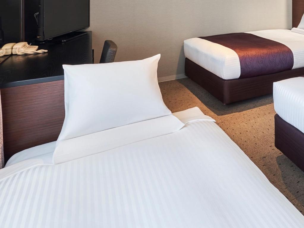 Postel nebo postele na pokoji v ubytování HOTEL MYSTAYS Shimizu