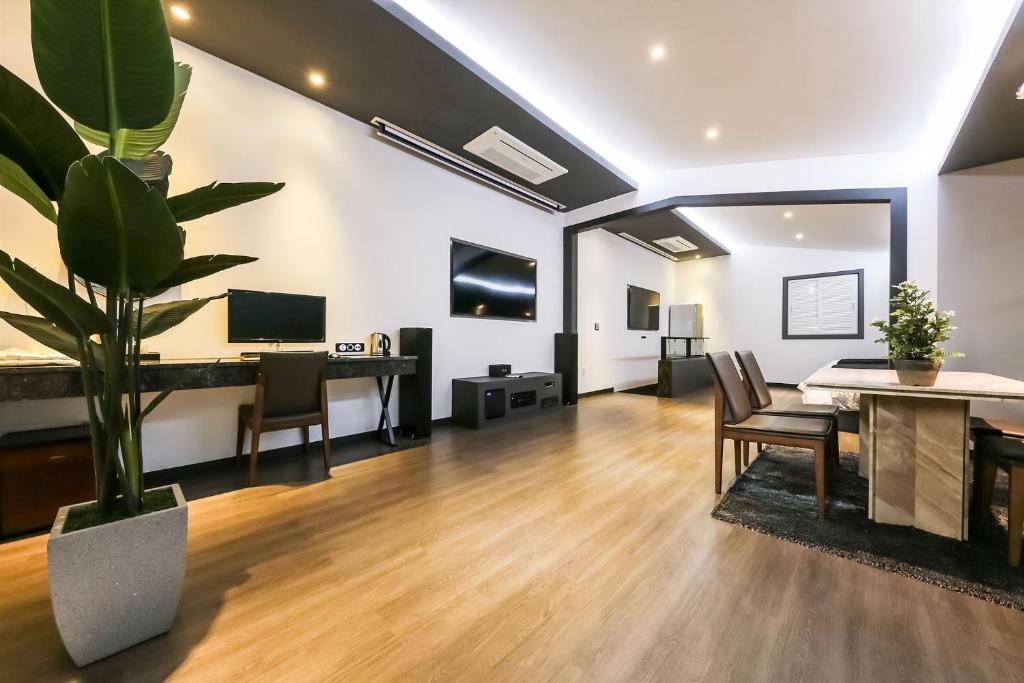 a living room with a table and a potted plant at Seosan Aria Hotel in Seosan