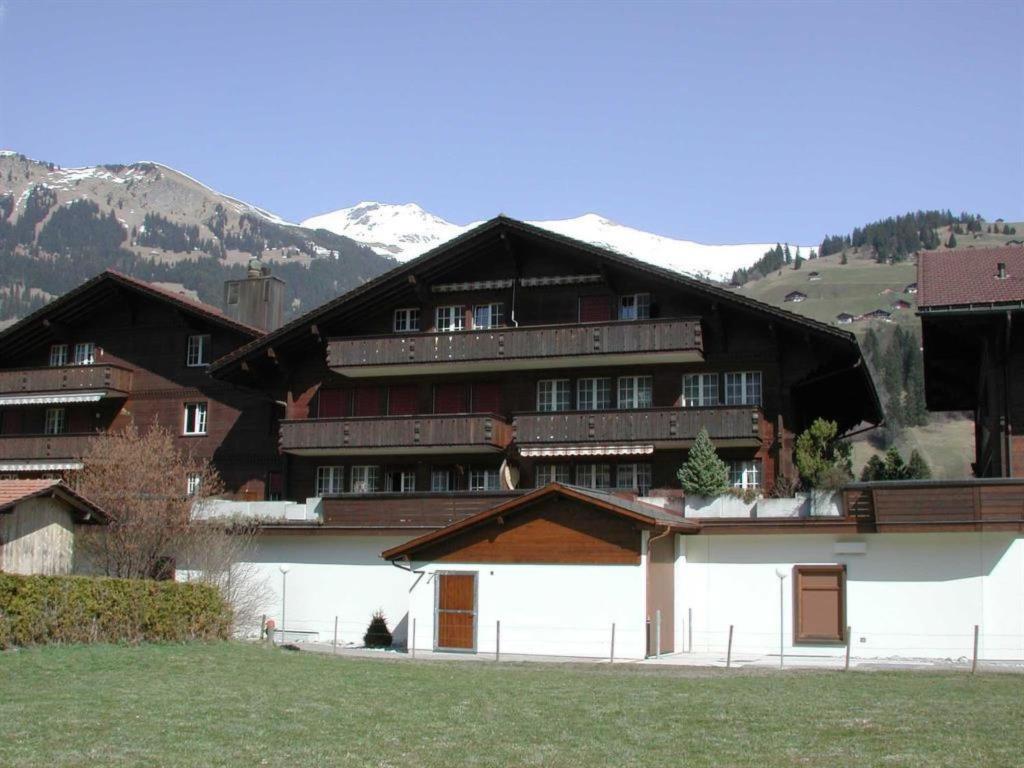 a large wooden building with mountains in the background at Apartment Kronenplatz 6 # 2 by Interhome in Lenk