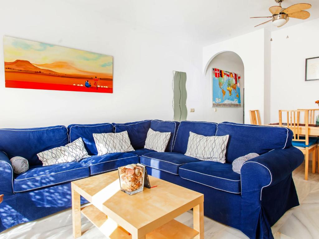 Sofá azul en la sala de estar con mesa en Apartment Edif- Museo 2ºk by Interhome, en Torre de Benagalbón
