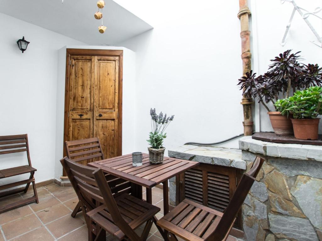 アルクーディアにあるHoliday Home Lencant by Interhomeの木製テーブルと椅子付きのパティオ