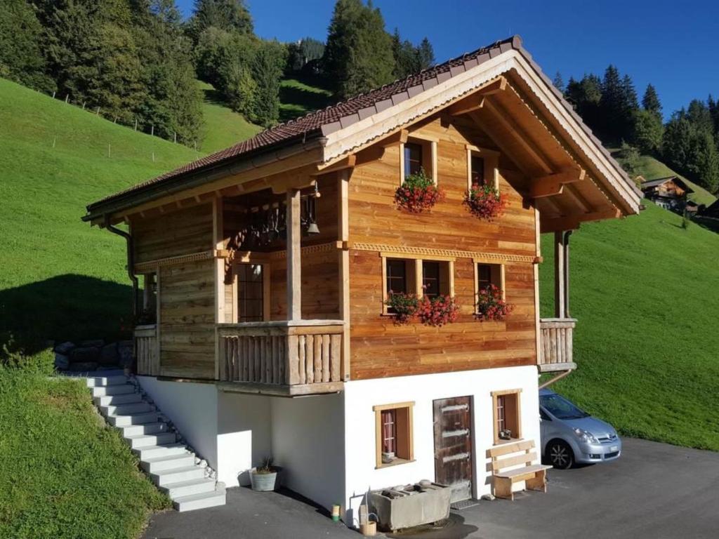 una piccola casa in legno con un'auto parcheggiata di fronte di Apartment Chalet Wäschhüsi by Interhome ad Adelboden