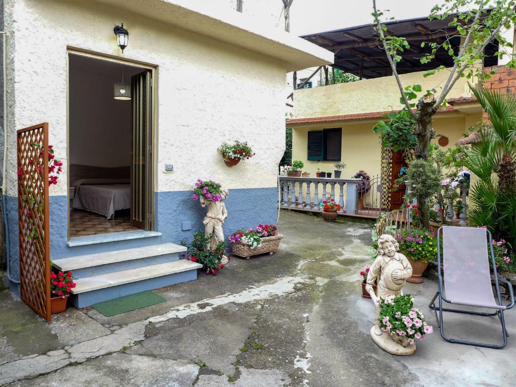 une maison dotée d'une terrasse couverte avec un lit et des fleurs dans l'établissement Holiday Home Il Piccolo Nocelleto by Interhome, à SantʼAgata sui Due Golfi