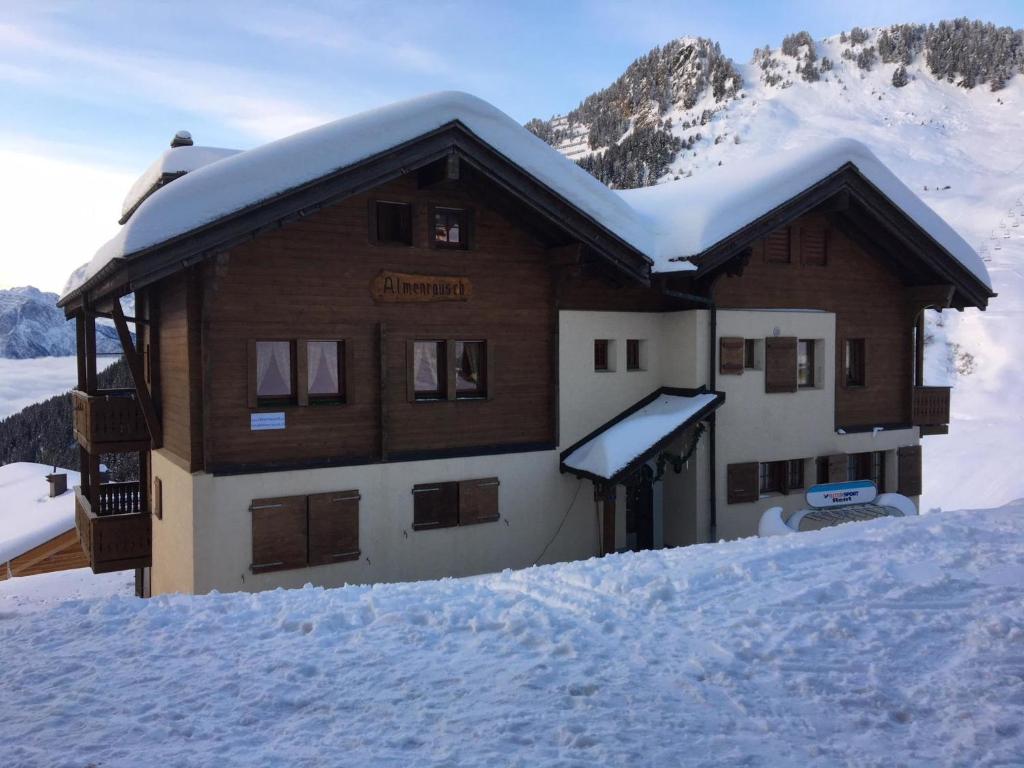 a building in the snow with snow on the roof at Apartment Almenrausch Parterre by Interhome in Riederalp