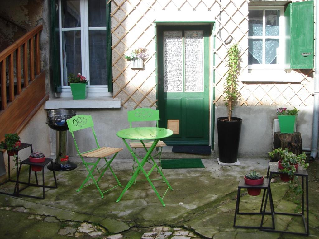 a green table and chairs in front of a house at Gîte L'Ermitage in Tours