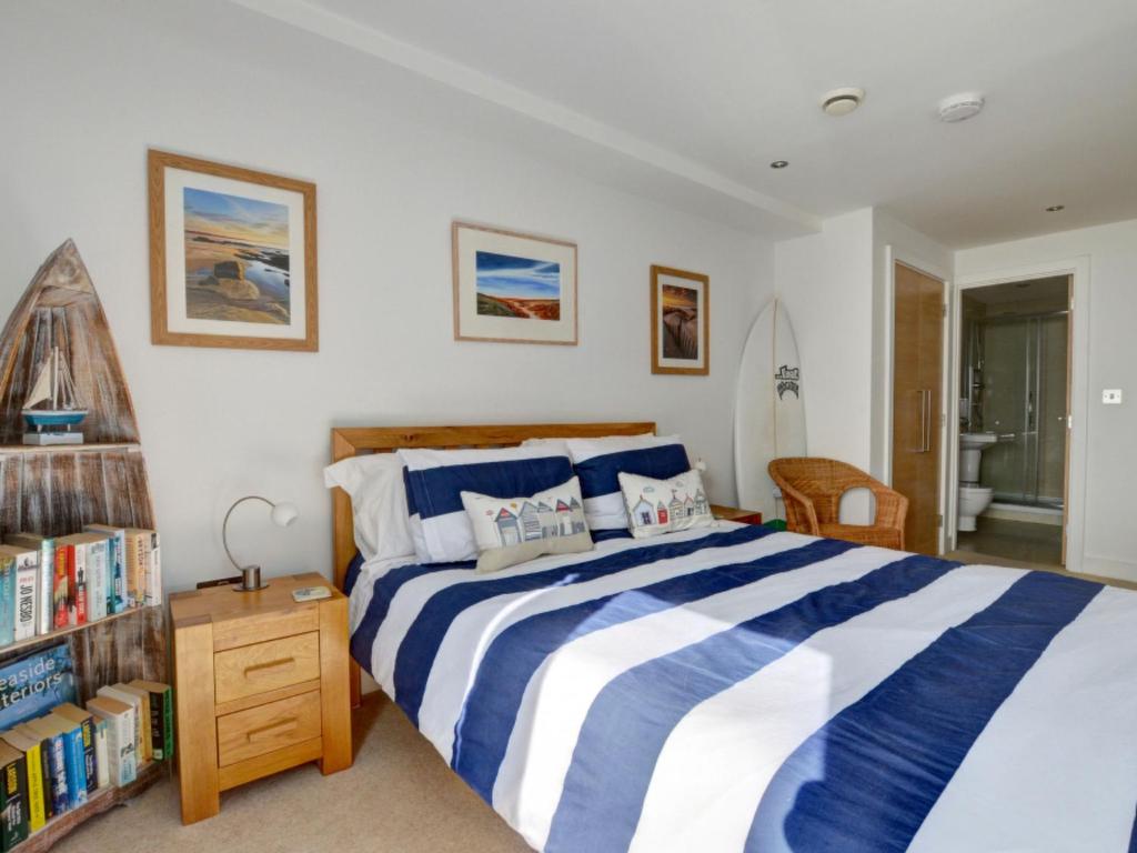 クロイドにあるApartment 2 Ocean Point by Interhomeのベッドルーム(青と白のベッド1台、本棚付)