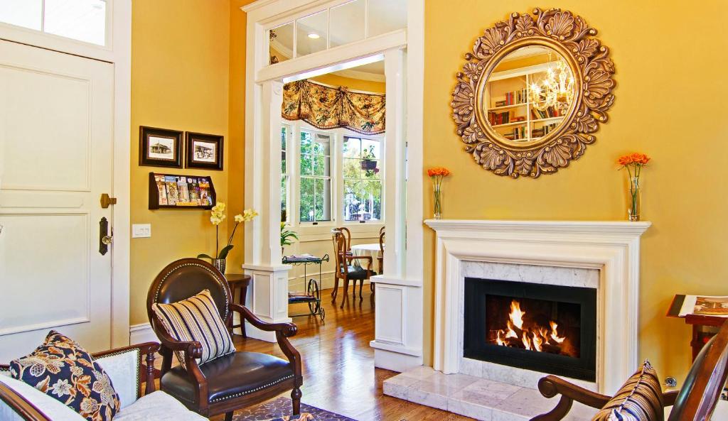 a living room with a fireplace and a mirror at Inn at Depot Hill in Capitola