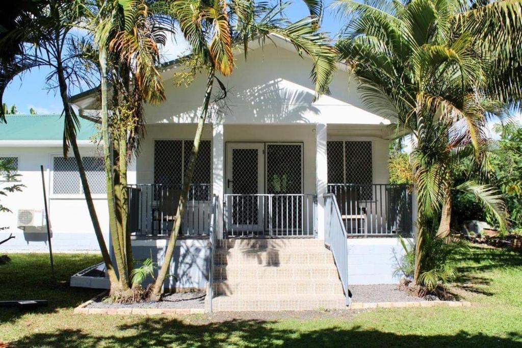 a white house with palm trees in front of it at Lotopa Home in Apia