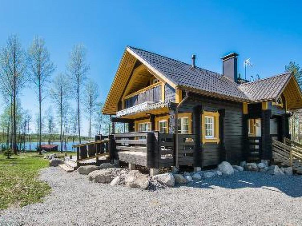 a large wooden house on top of a gravel yard at Holiday Home Runopuro by Interhome in Kerkonjoensuu