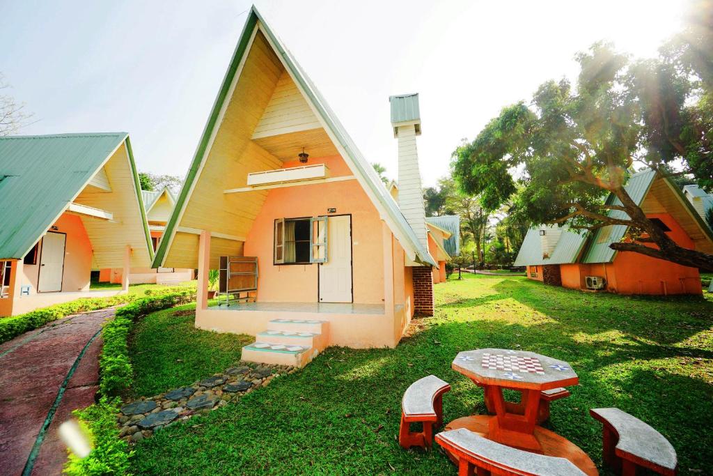 ein Haus mit einem Tisch und Bänken im Hof in der Unterkunft Touch Star Resort - Doi Inthanon in Chom Thong