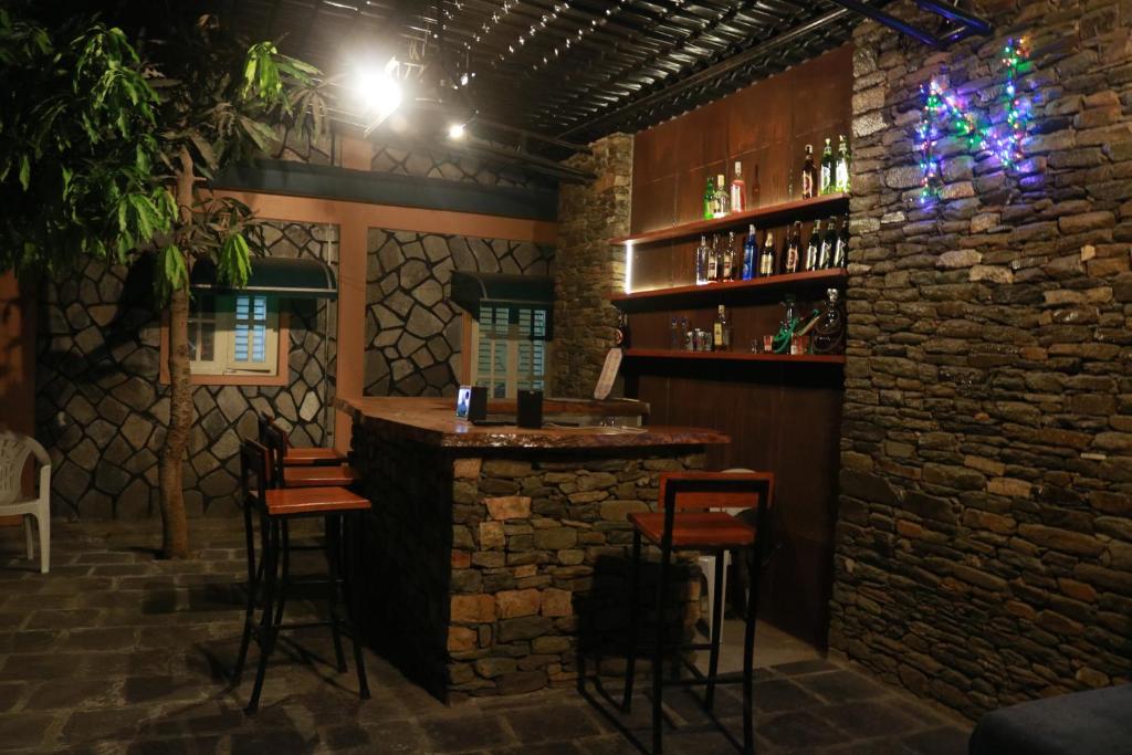 un bar en una habitación con una pared de piedra en Hotel Nana Pokhara, en Pokhara