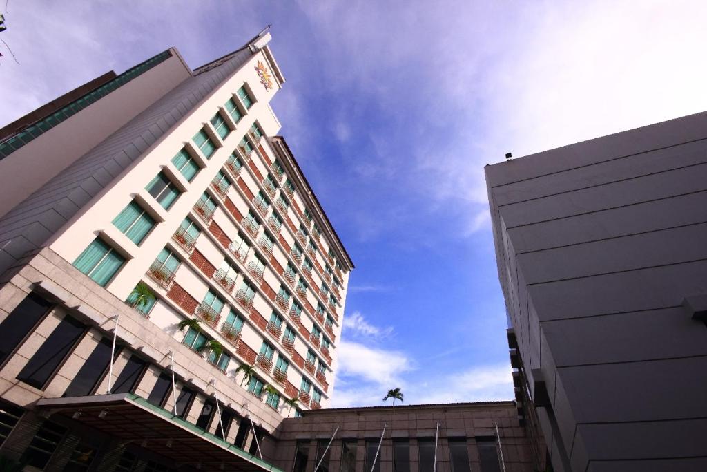 a tall building with a blue sky in the background at Grand Surya Hotel Kediri in Kediri