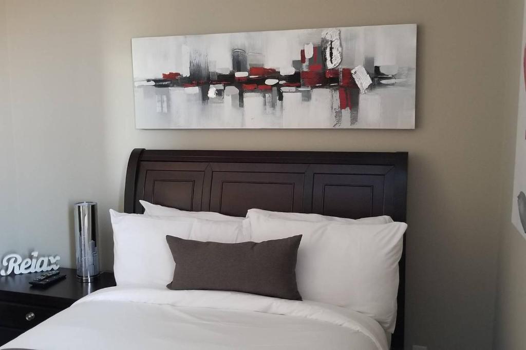 um quarto com uma cama e um quadro na parede em 1-Bedroom Cozy Sweet #22 by Amazing Property Rentals em Gatineau