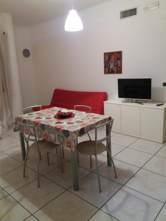 salon ze stołem i czerwoną kanapą w obiekcie Appartamento Residence Baia Blu w mieście Gallipoli