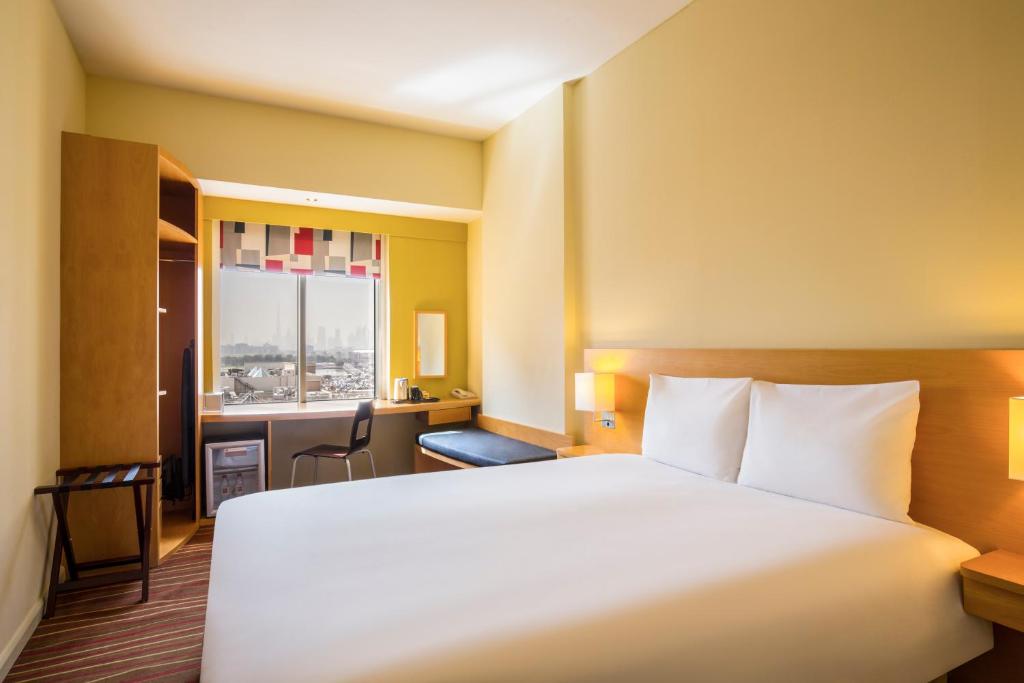 a hotel room with a large bed and a window at Ibis Deira Creekside Dubai in Dubai