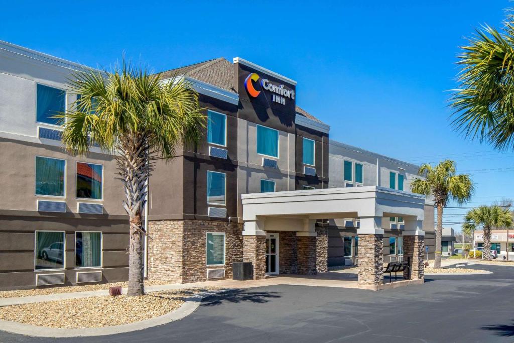 un hôtel avec un palmier en face dans l'établissement Comfort Inn N Myrtle Beach Barefoot Landing, à Myrtle Beach