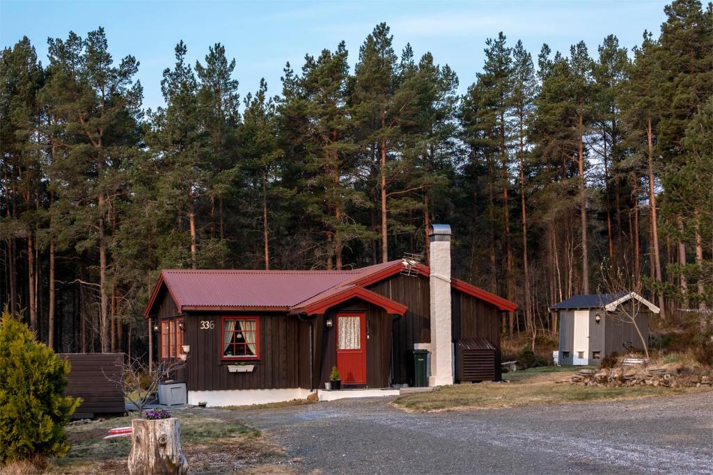a small cabin with a red roof in the woods at Iverhjelen Near Atlantic Road in Lyngstad