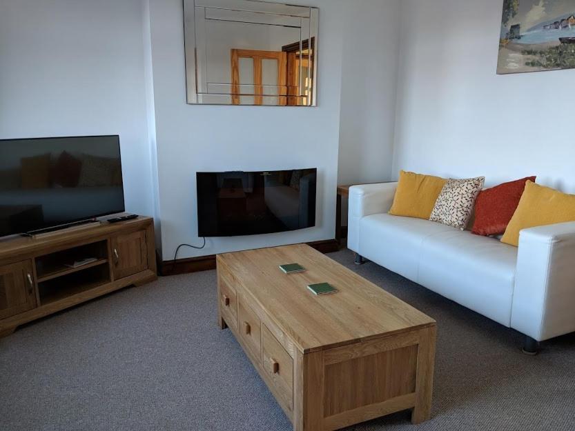 a living room with a couch and a tv and a coffee table at Avon House in Telford