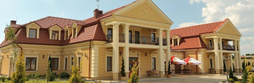 a large yellow building with a red roof at Jaśminowy Dwór in Rokietnica