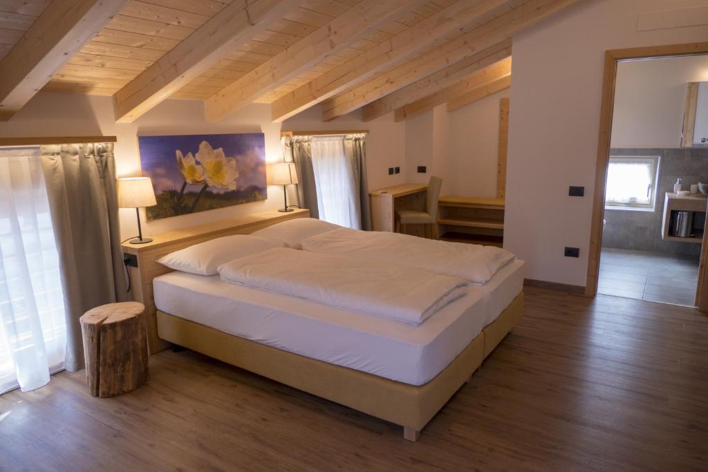 ein Schlafzimmer mit einem großen Bett in einem Zimmer in der Unterkunft Agritur Piccolo Fiore B&B in Thayl