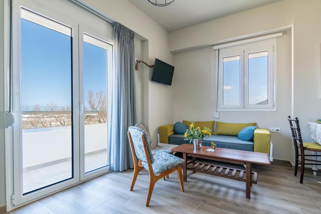 a living room with a couch and a table at Kyma seaview Apartments, Episkopi beach Rethymno in Karotí