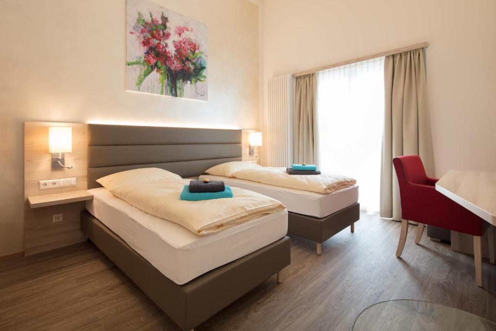 um quarto de hotel com duas camas e uma janela em Hotel Gudrun em Riedlingen