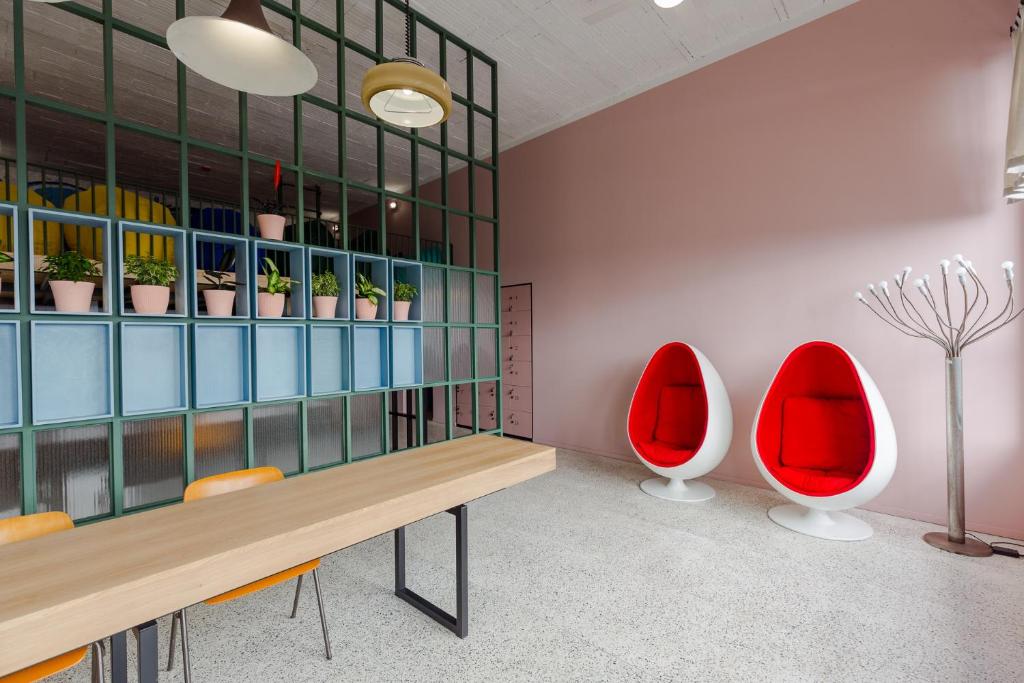 Pokój z czerwonymi krzesłami, stołem i półkami w obiekcie Back2ME w mieście Batumi