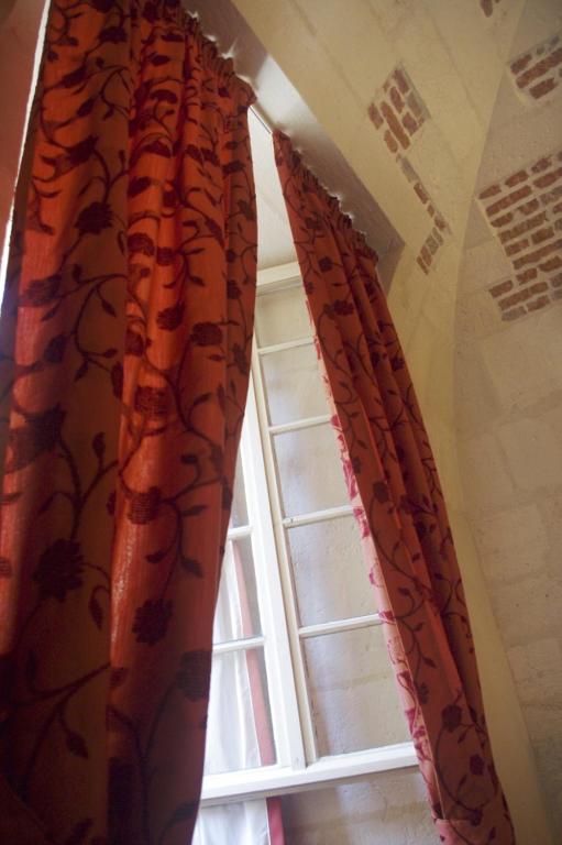 une paire de rideaux devant une fenêtre dans l&#39;établissement Les Chambres de l&#39;Abbaye, à Saintes