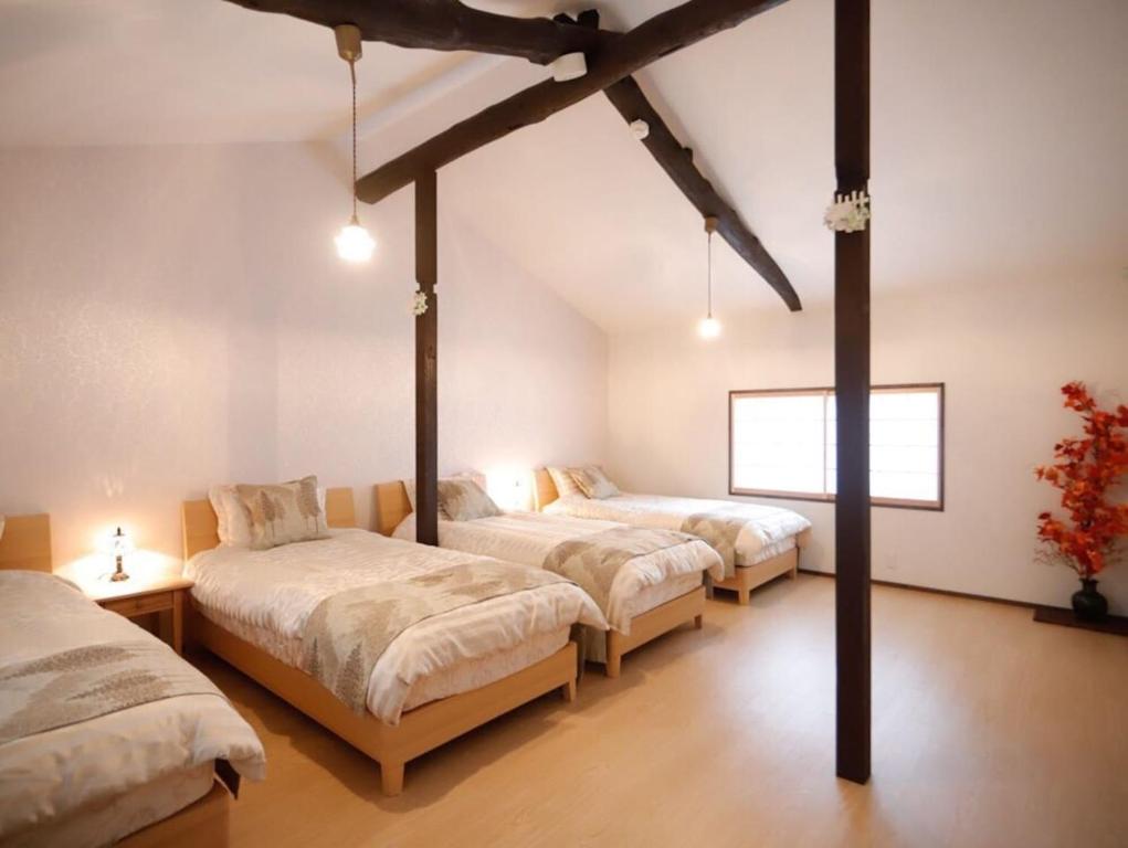 une chambre avec trois lits dans une pièce dans l'établissement Nice Kyoto, à Kyoto