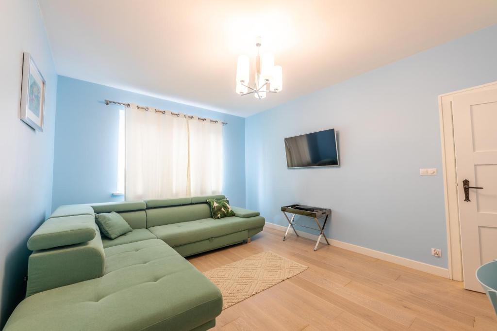 ソポトにあるVictus Apartamenty, Apartament Romaのリビングルーム(緑のソファ、テレビ付)