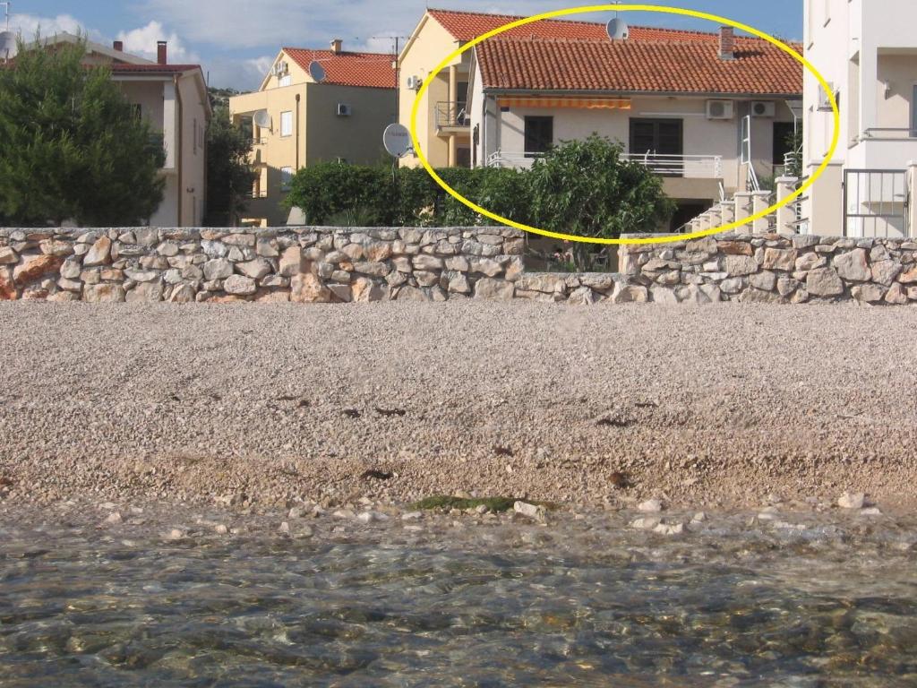 a yellow circle on a stone wall next to a house at Apartments Mira - 20 m from pebble beach in Zaboric