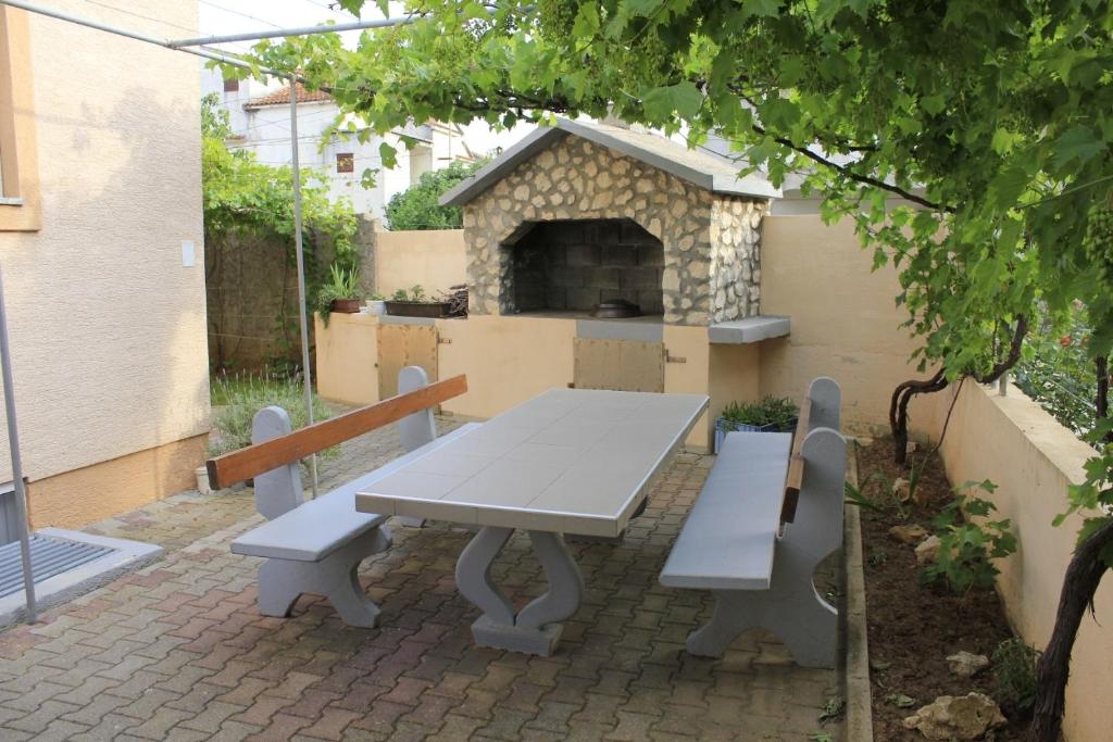 un tavolo da picnic e 2 panche su un patio in mattoni di Apartments Ivan - 300 m from sea a Nin