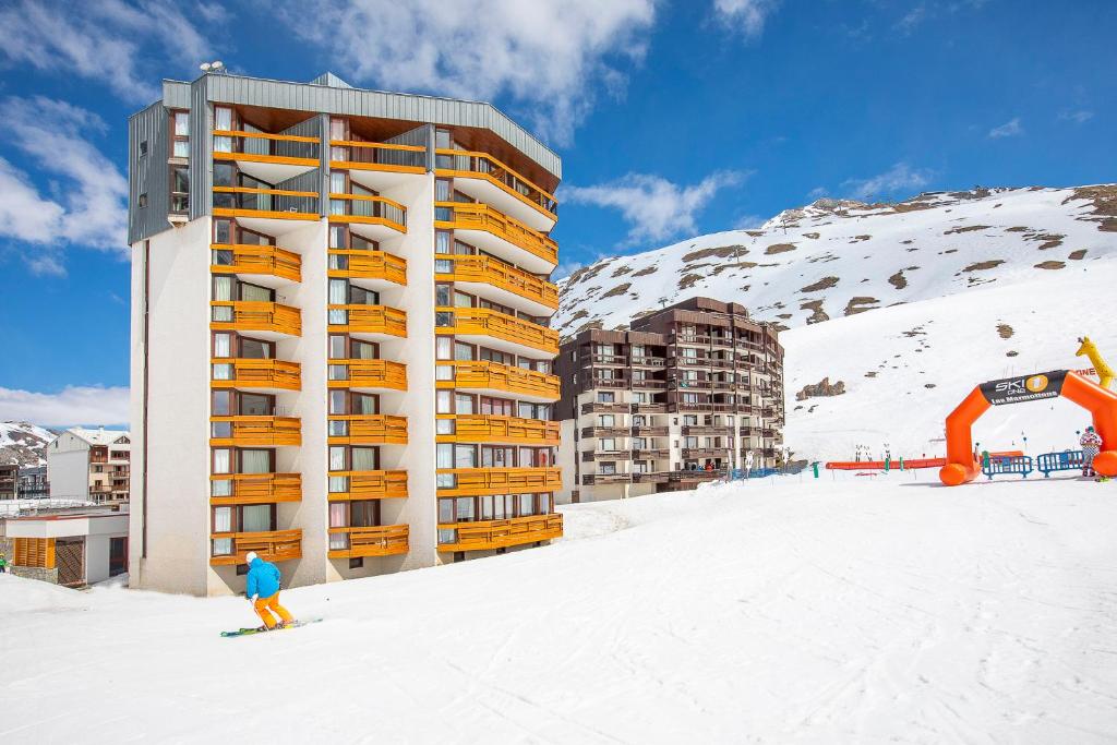 a person skiing in the snow in front of a building at Résidence Le Borsat - Tignes Val Claret in Tignes