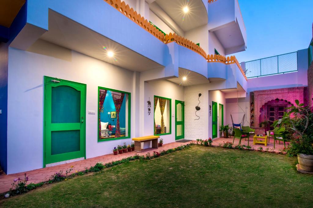 a house with green doors and a yard at Coral Country Homestay in Agra